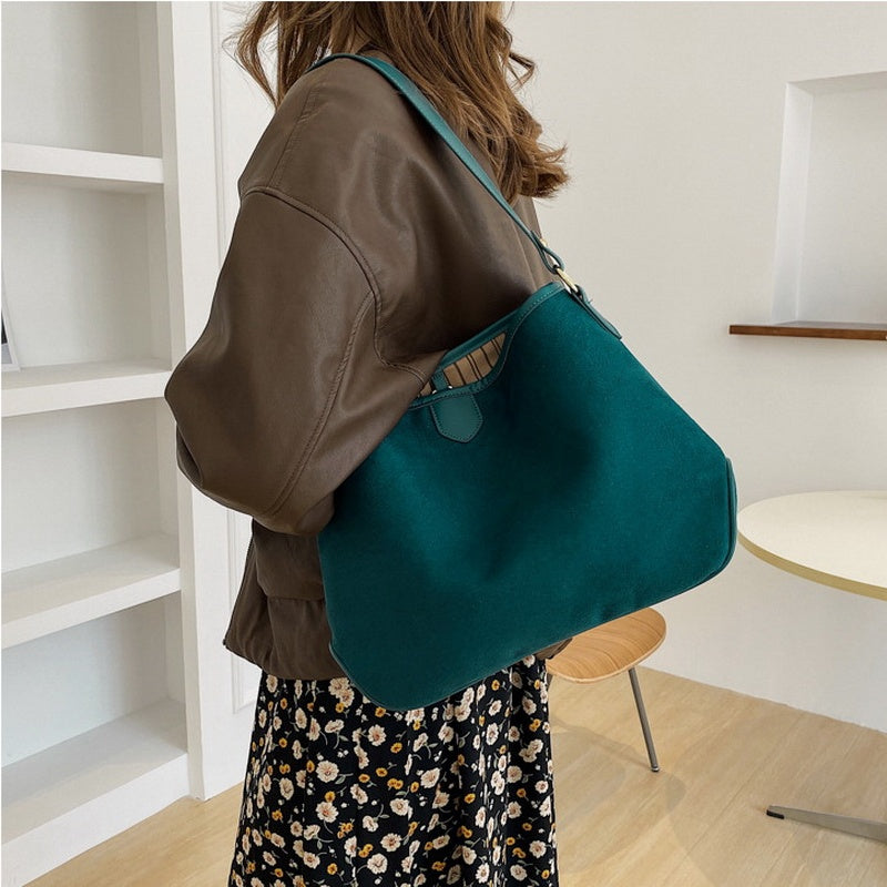 Stylish shoulder bag in teal worn by a model, showcasing a vintage retro soft leather design.