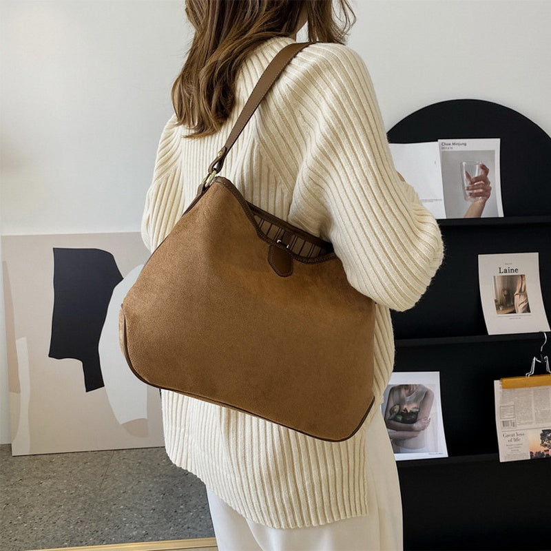 Vintage retro matte soft leather tote shoulder bag in khaki color worn crossbody style with a cozy knit sweater.